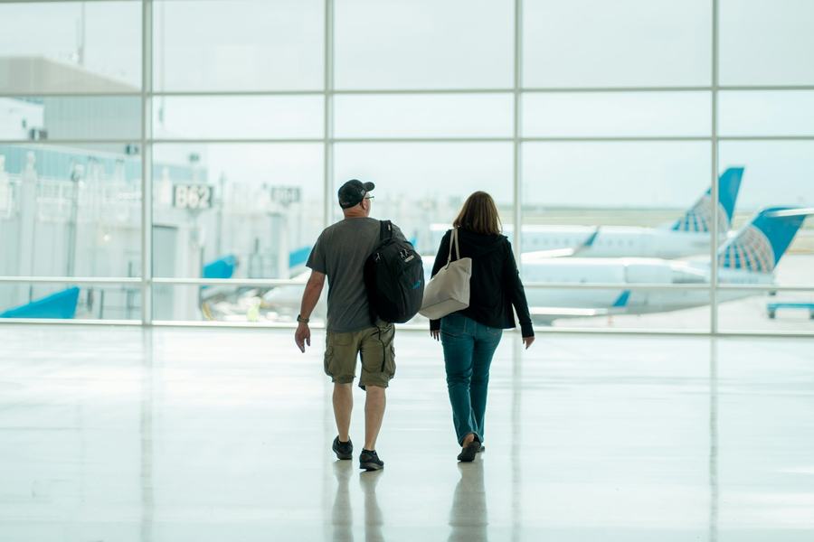 Two travellers walking through an airport terminal