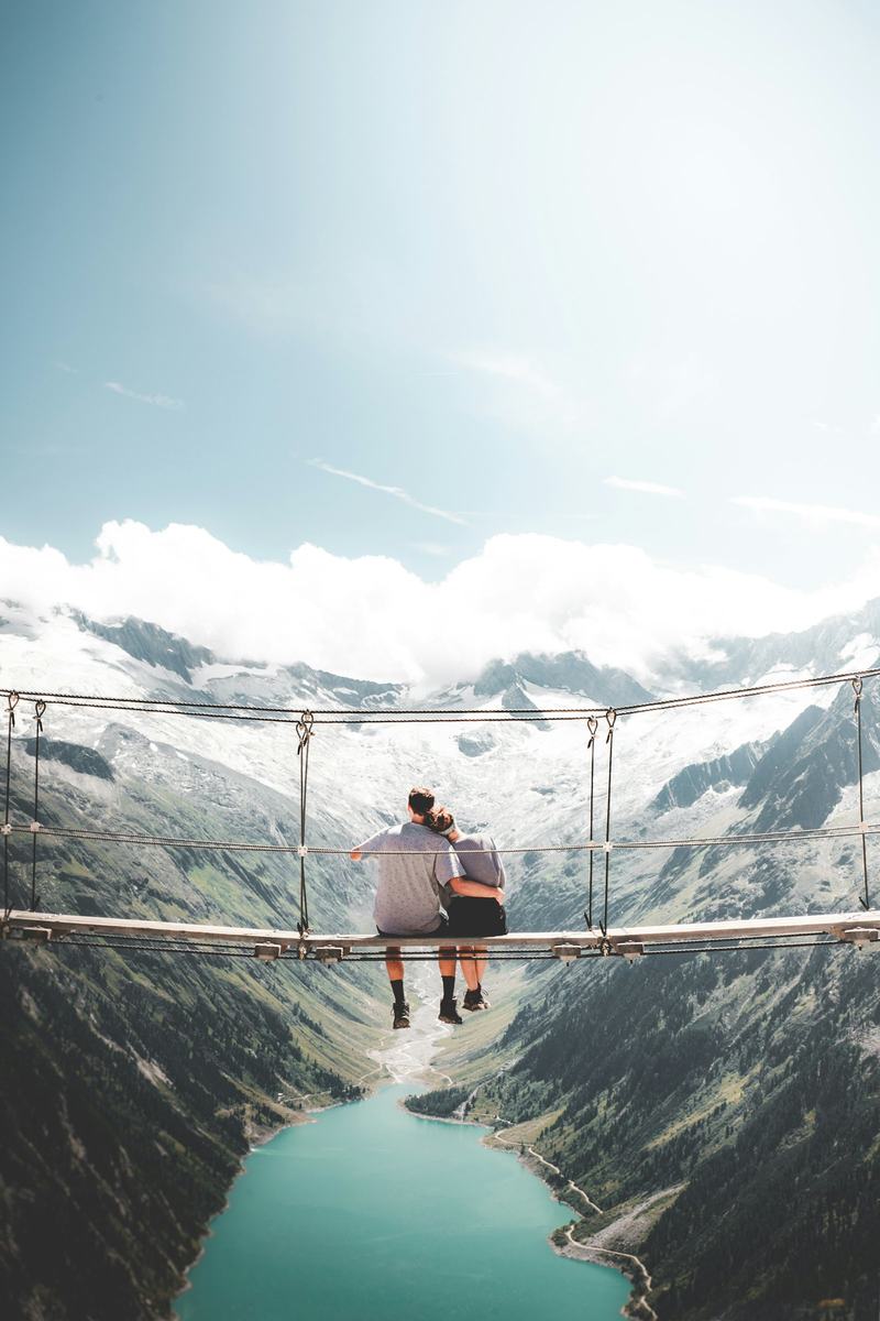Couple on a bridge above a mountain lake