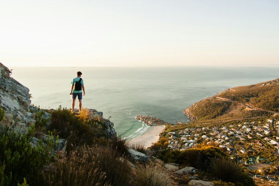 Traveller on a clifftop above a Cape bay