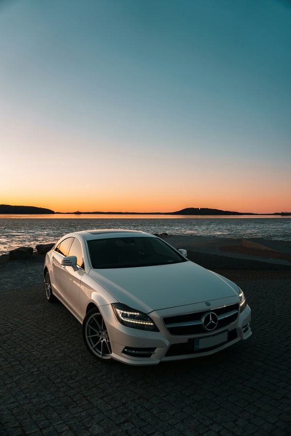 Silver Mercedes sedan at sunset by the sea